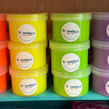 Stacks of colorful containers with labels on a shelf