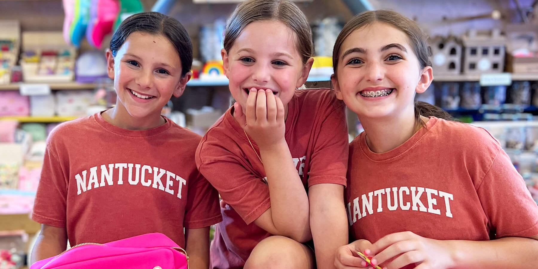3 smiling girls in the Barnaby's Toy & Art store wearing Nantucket shirts doing a class