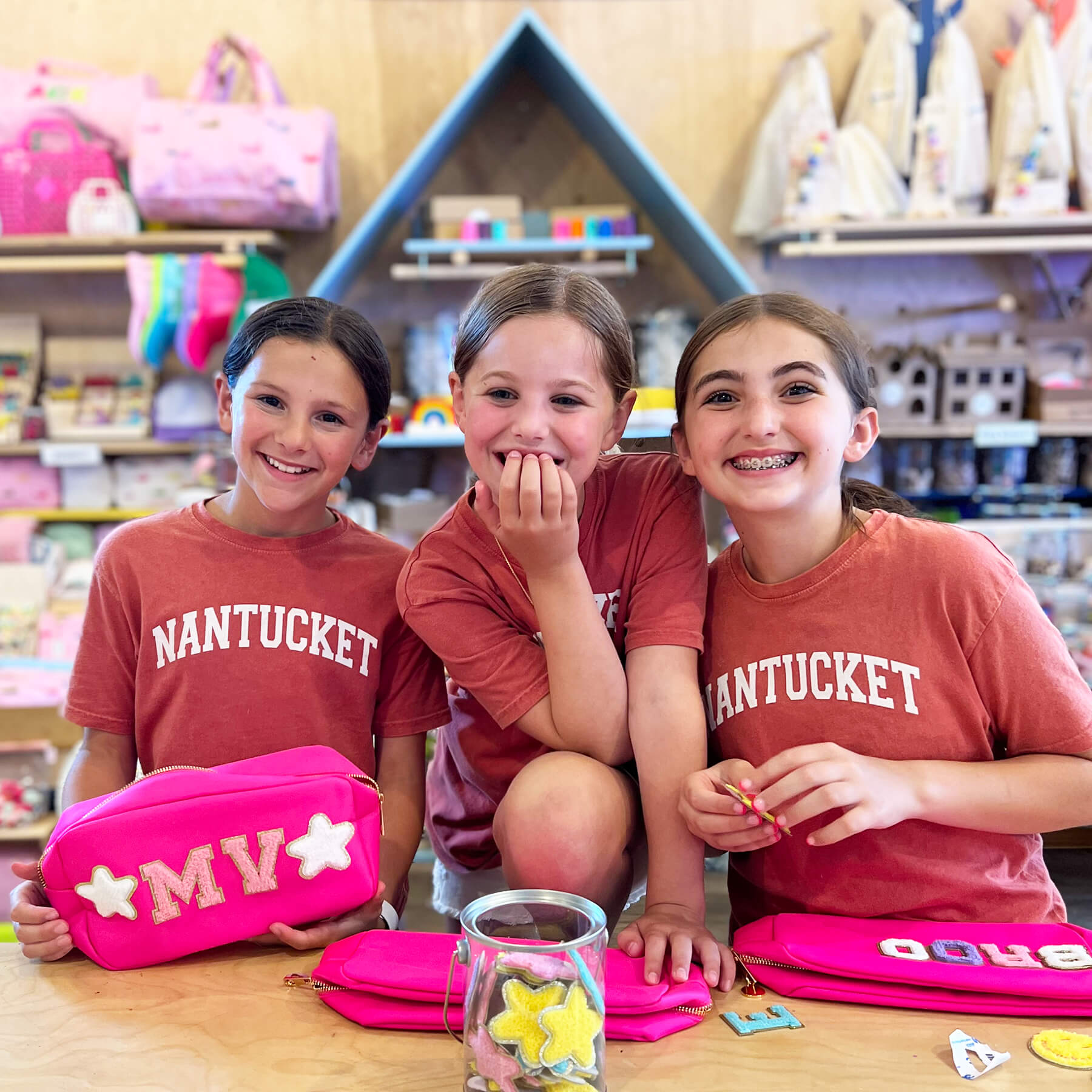 3 smiling girls in the Barnaby's Toy & Art store wearing Nantucket shirts doing a class